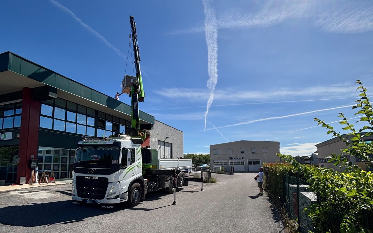 Autogrù Volvo che solleva un carico sul tetto di un edificio