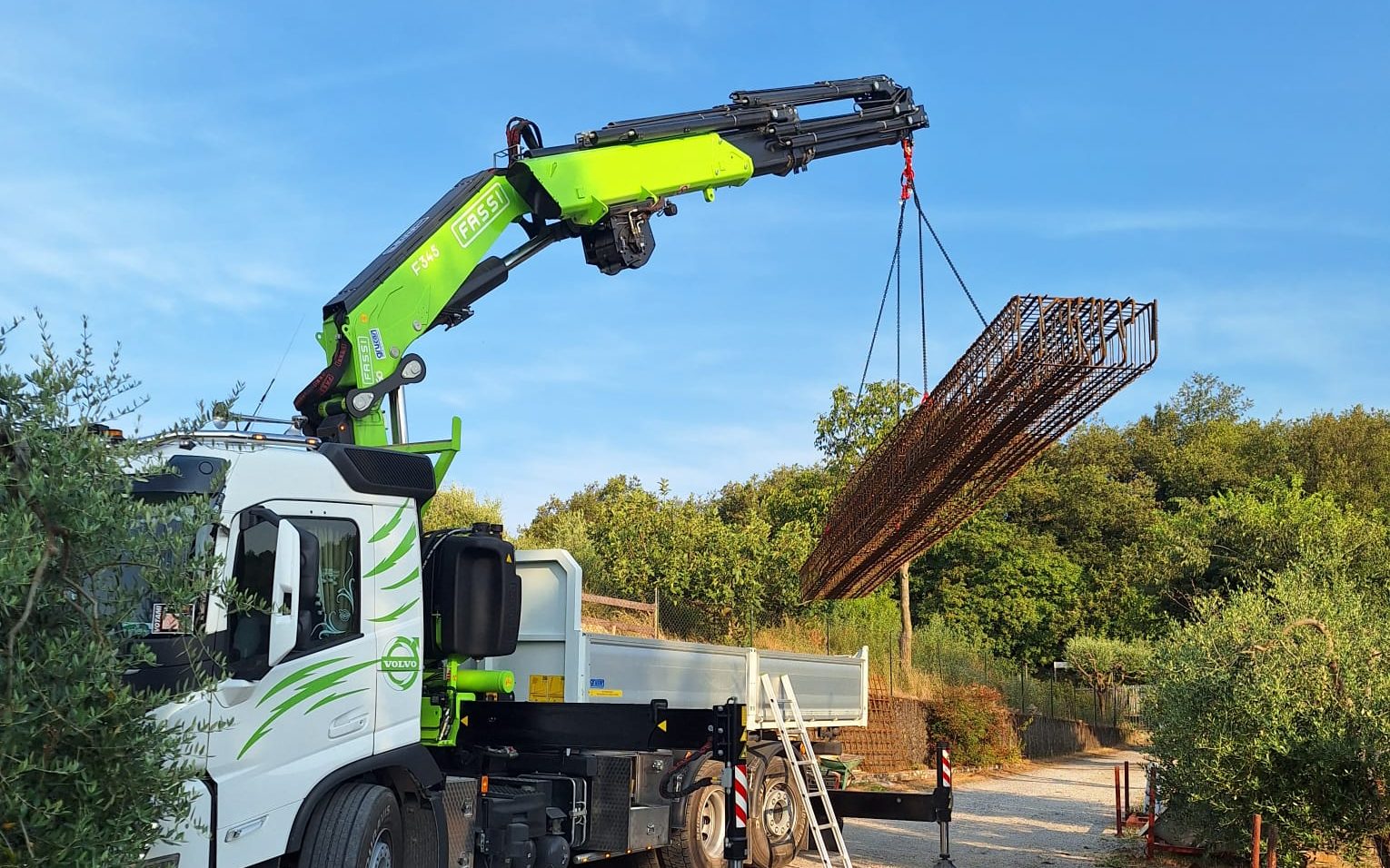 Autogrù che solleva una gabbia d'armatura in ferro per un cantiere sul Garda