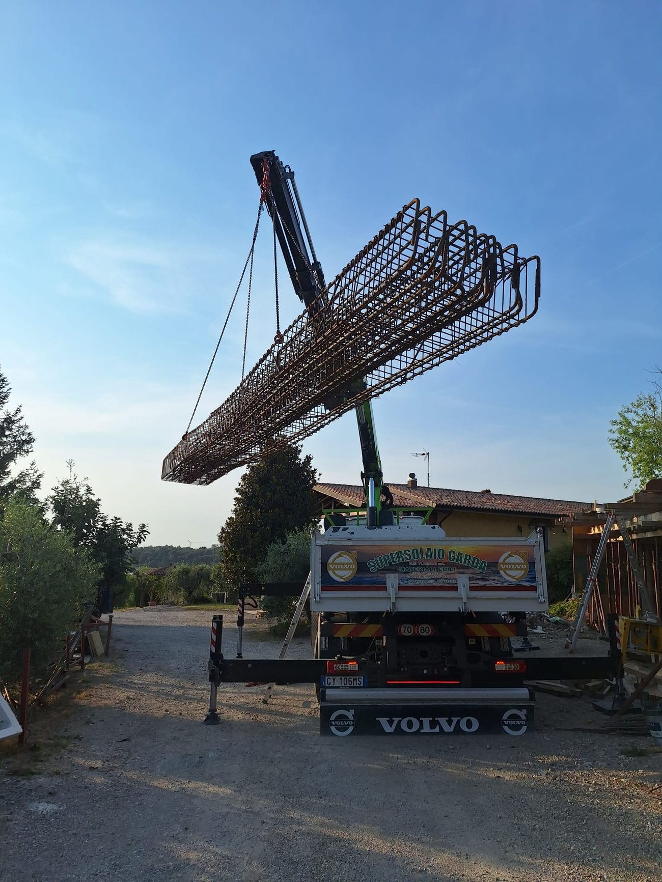 Gabbie d'armatura in ferro sollevate dall'autogrù per la consegna in cantiere